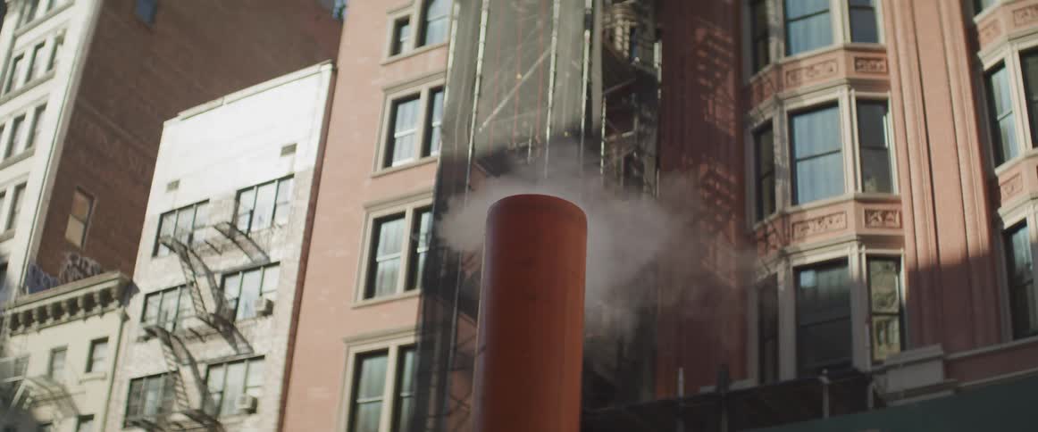 Smoke emitting from a small smokestack in a city