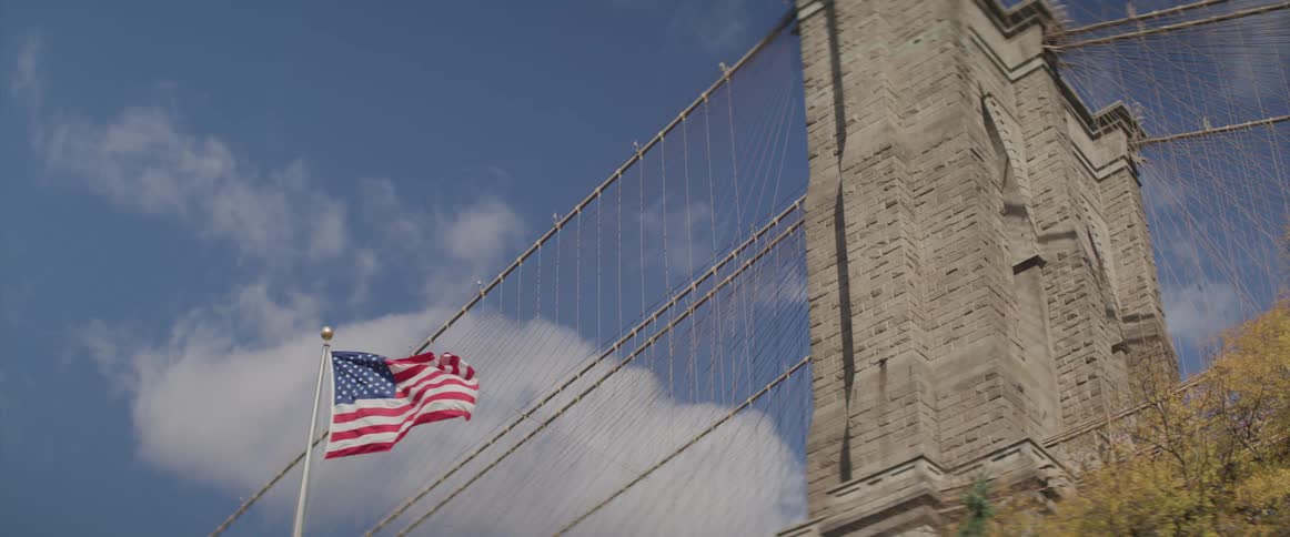American flag blows in the breeze near a cement structure