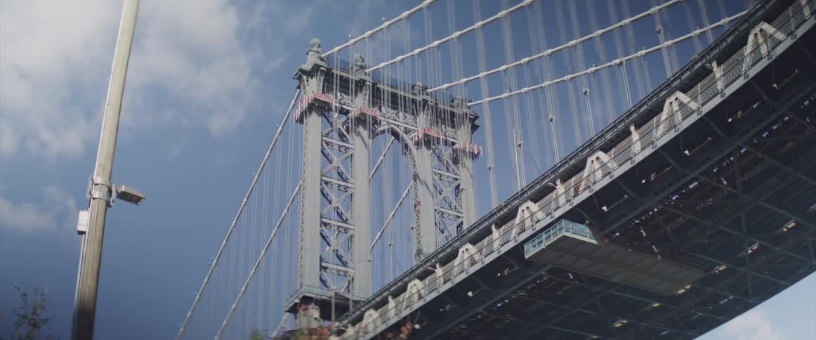 Vehicles drive across a suspension bridge on a clear day