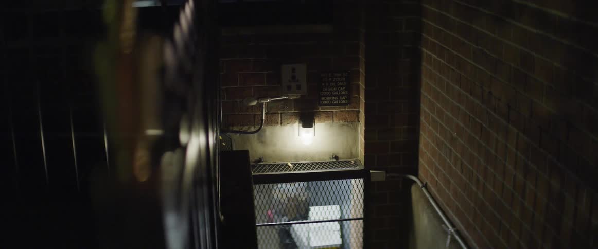 A stairwell in brick apartment building leads to basement storage