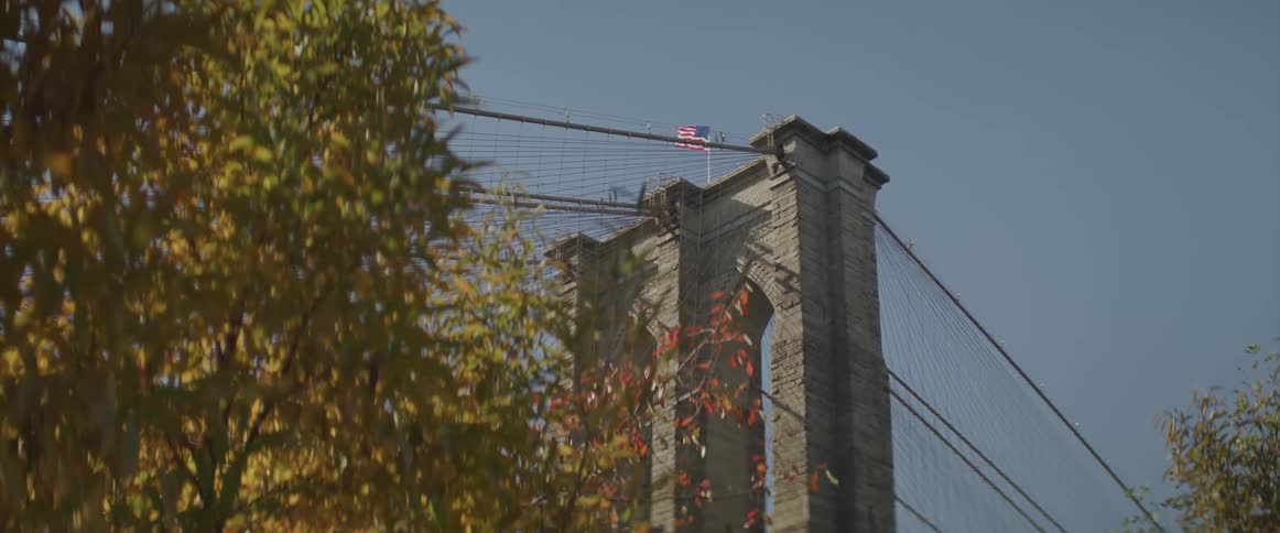 View of brooklyn bridge tower and the american flag flying