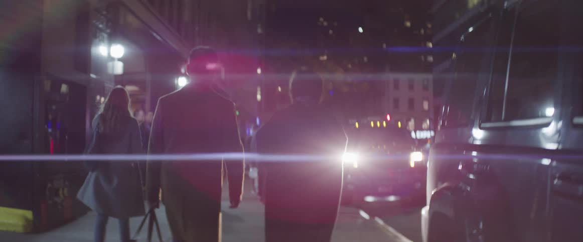 People walking down a city street at night