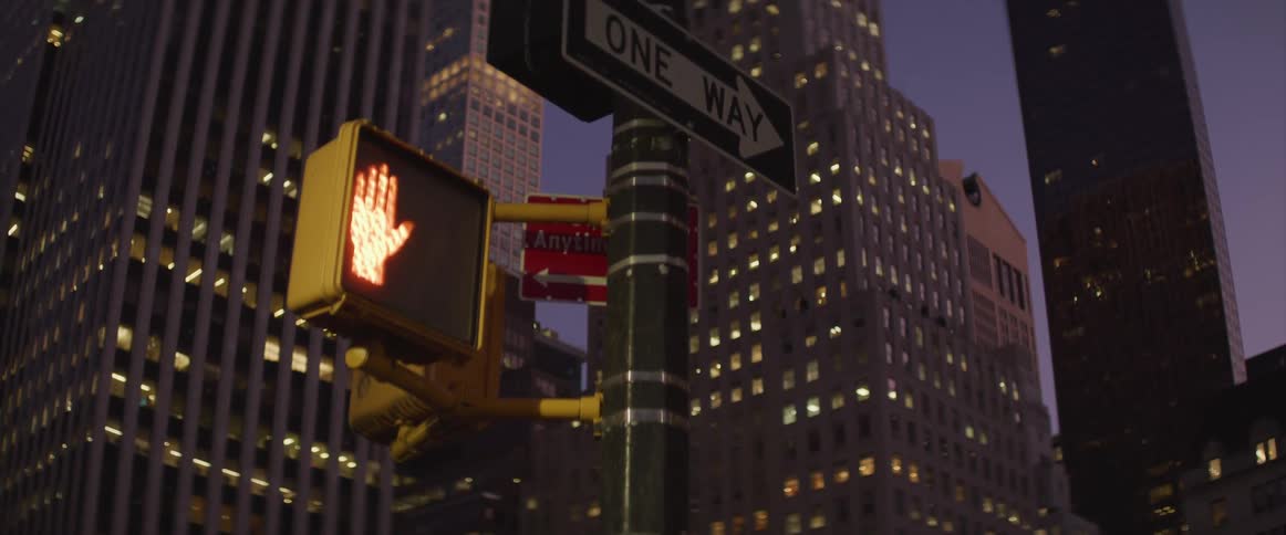 A blinking crossing signal in a city at night