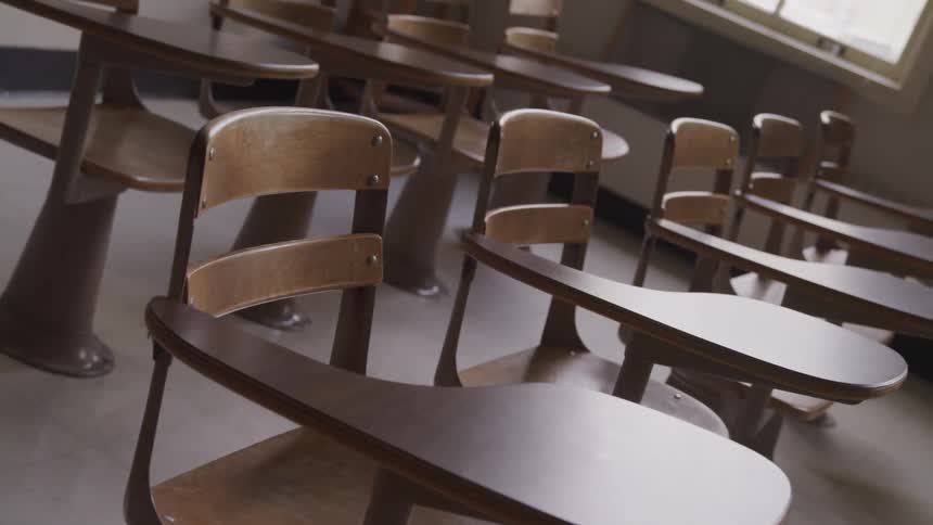 Rows of student desks sitting empty in a classroom