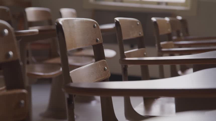Rows of wooden desks in a classroom