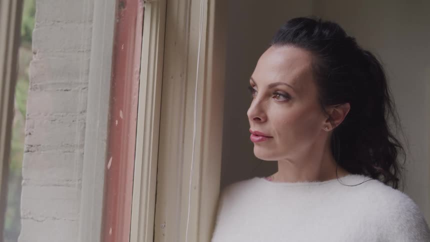 A woman looks out the window