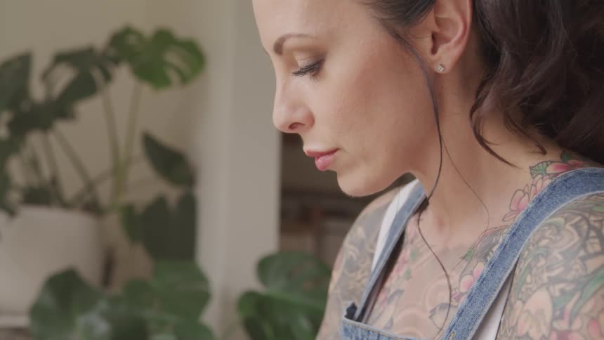 Side view of the tattooed woman looking down
