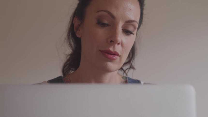 A woman looks at her laptop