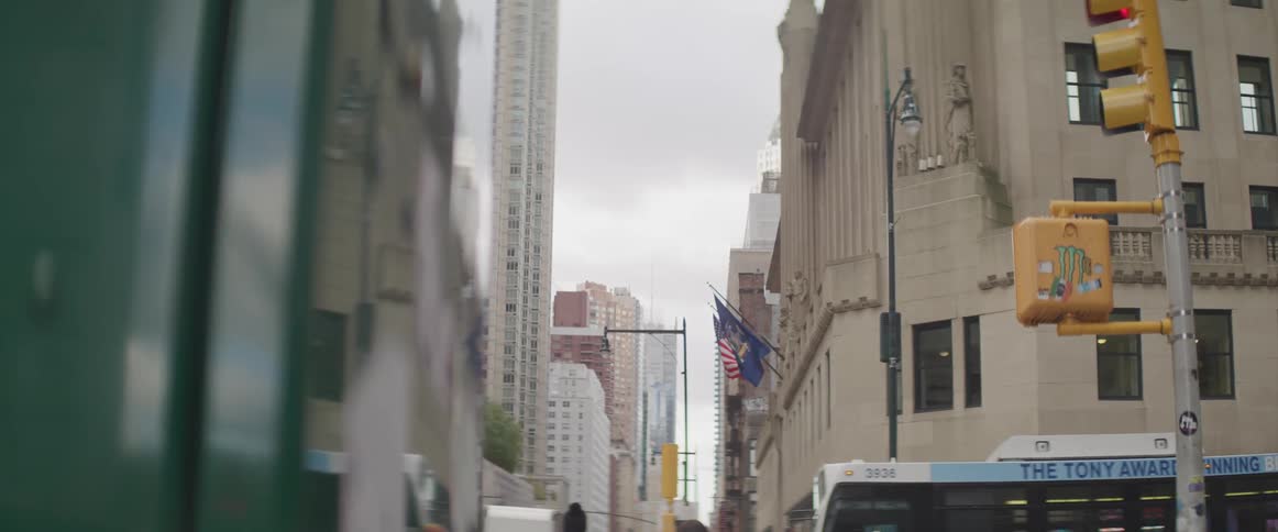 A city street with buildings people traffic lights and the sky in the background