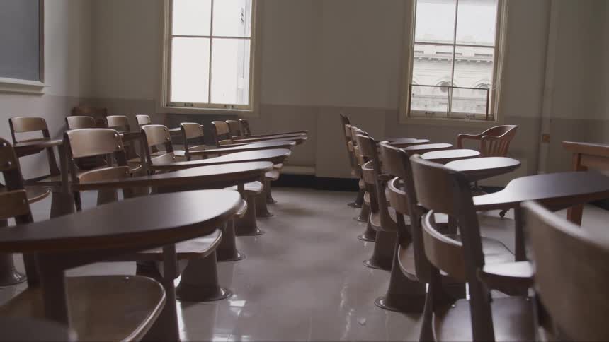 Empty desks sit in the classroom