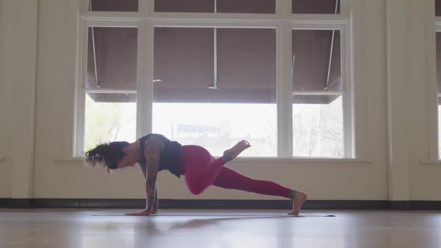 Tattooed woman works out in a room
