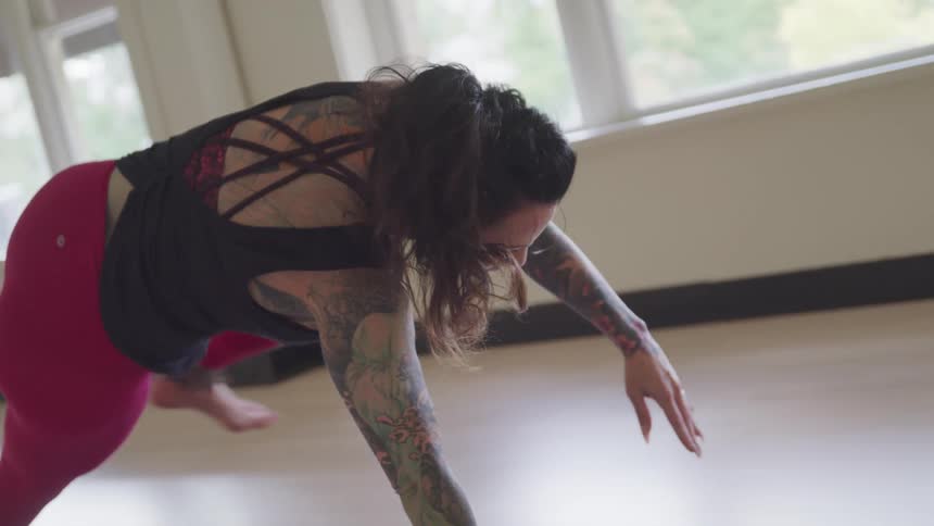 A woman exercises as she does yoga
