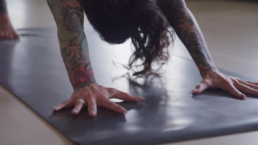 A woman with tattoos is doing yoga