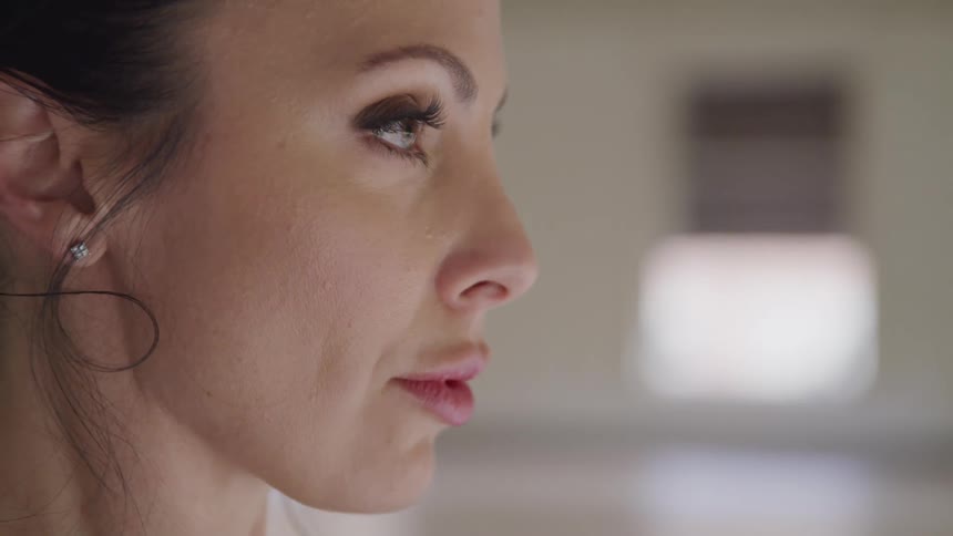 Woman looks in the mirror without blinking