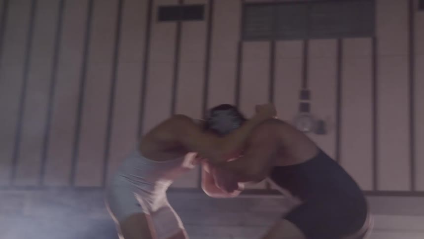 Two men in a leotard wrestling
