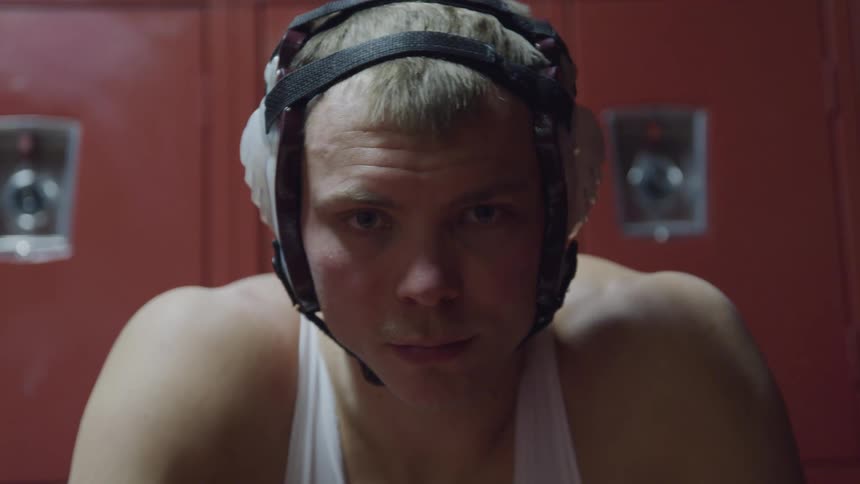 A wrestler sits in the locker room