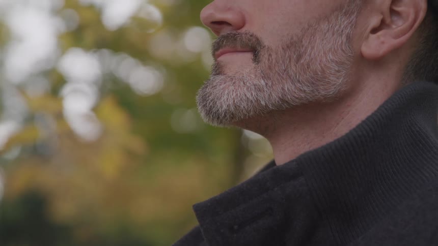 Bearded man stands and looks ahead in the public room