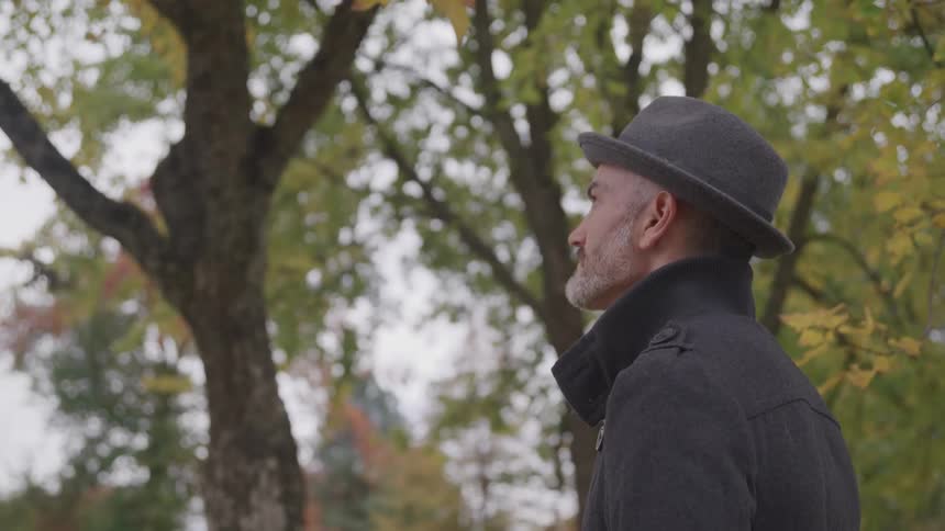 A man stands outside and looks off in to the distance