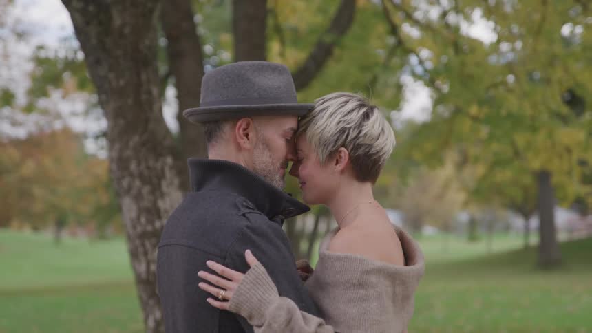 Romantic couple hugging outdoors near a tree at a park