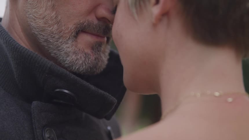 A man and woman lean their heads together
