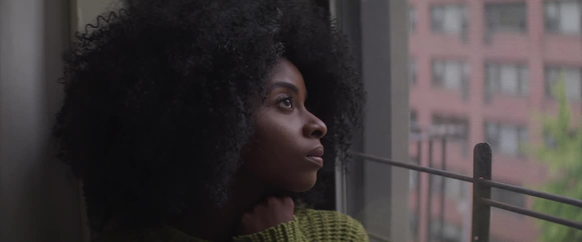 A woman sits looking out the window