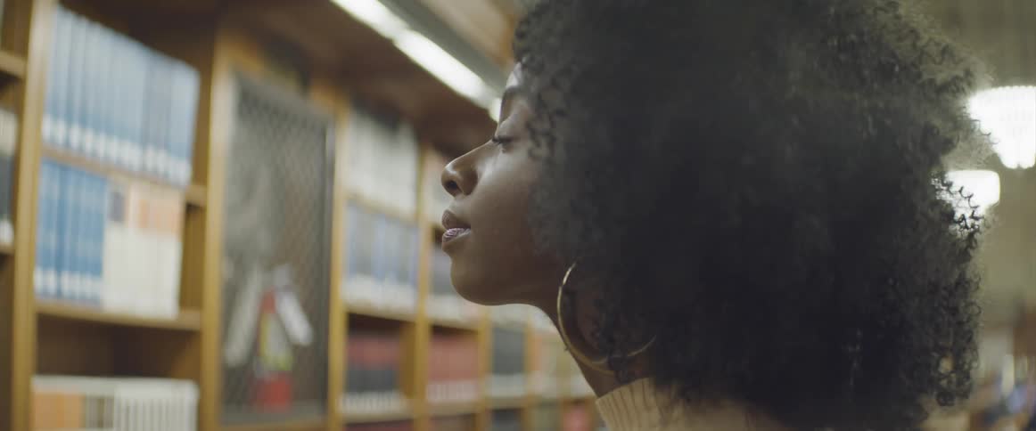 A woman is looking at books in the library