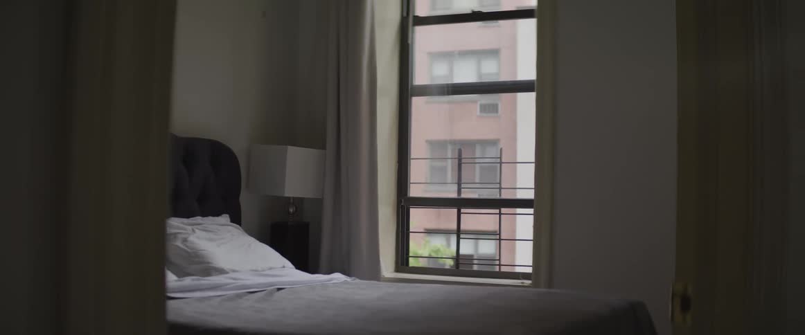 Pillows sit on the bed near a window in the bedroom