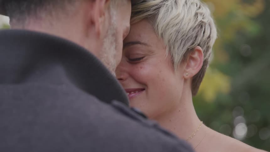 Bearded man and short haired woman stand face to face in the public park