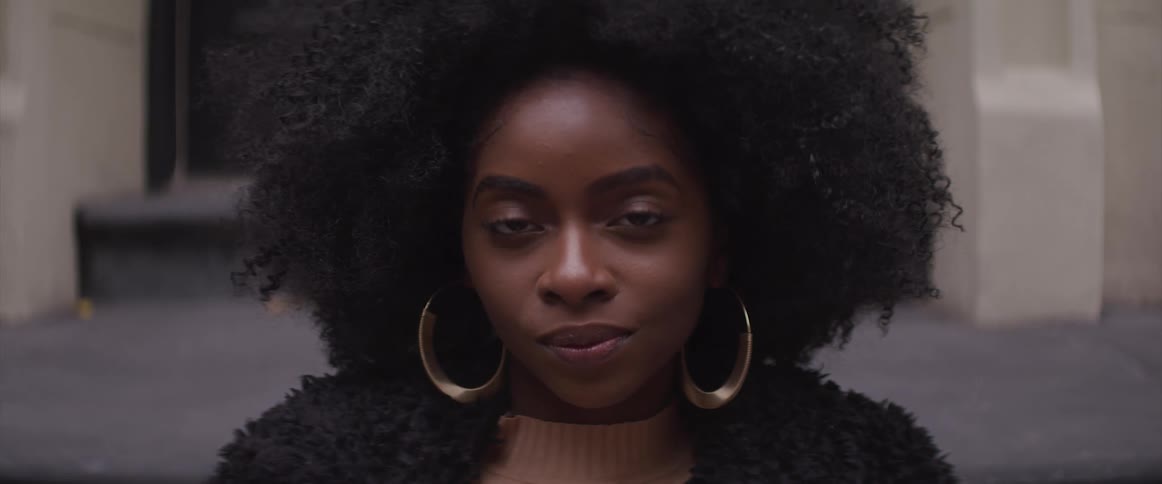 A black woman turns her head and looks forwards