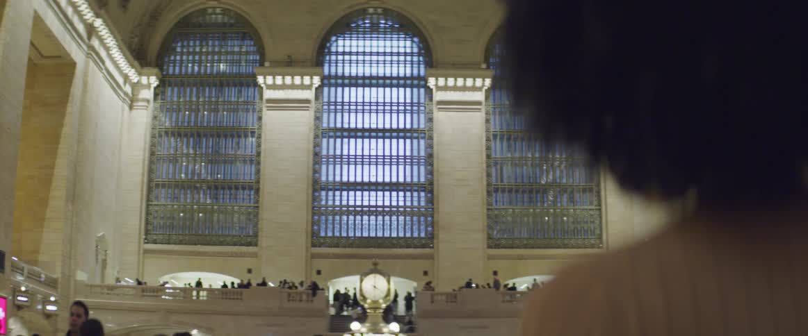 Black woman looks at the crowd as she stands in a large building