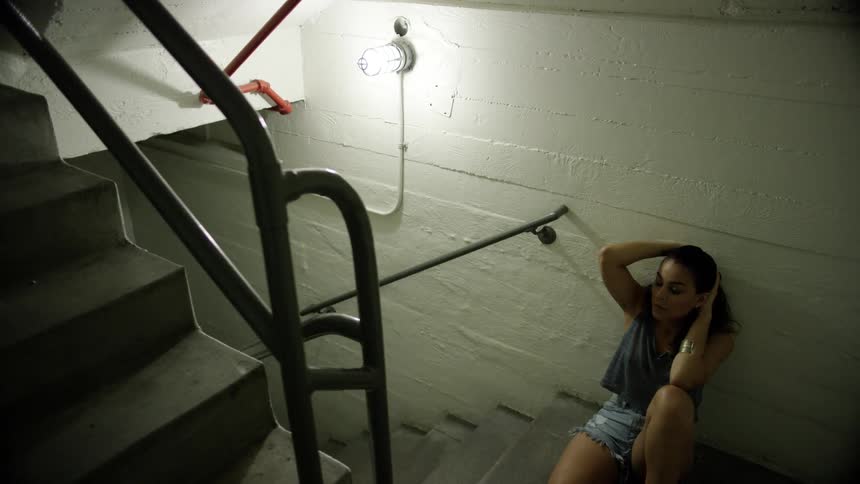 A teenager sits in a stairwell