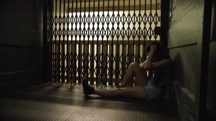 A woman sits in an elevator