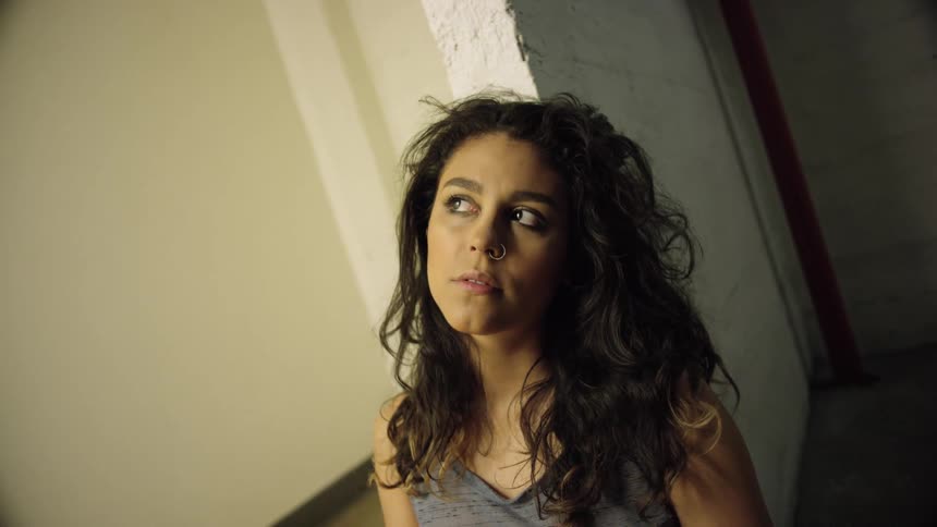 A teenager sits on the floor and looks around