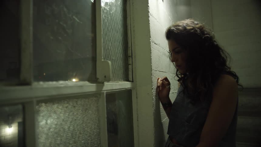Woman peeks out of the window at night