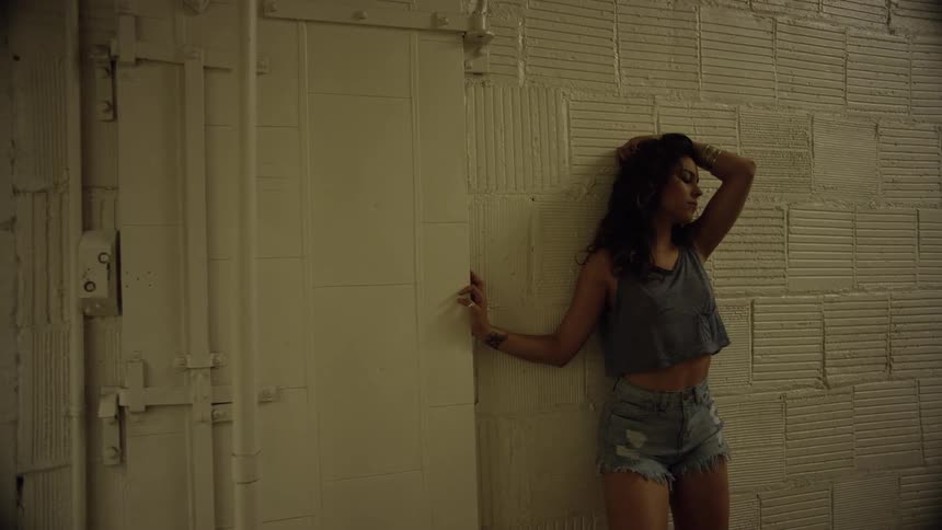 A woman leans against the building