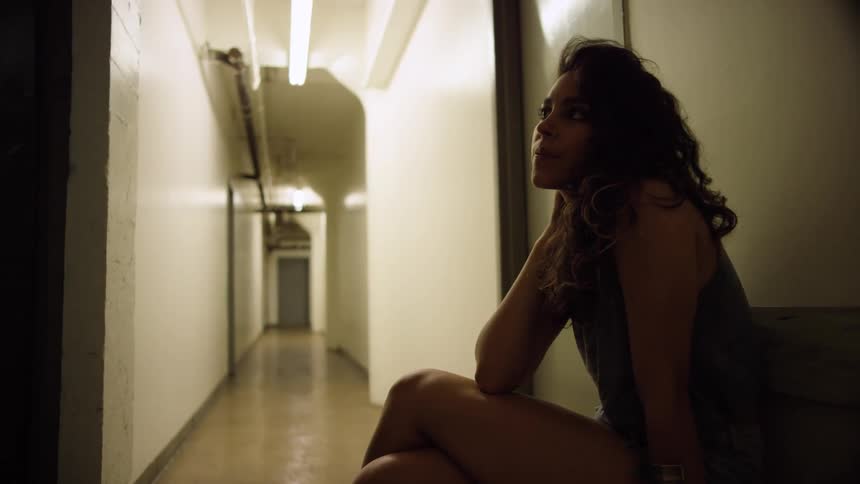 A woman sitting in a hallway with her legs crossed
