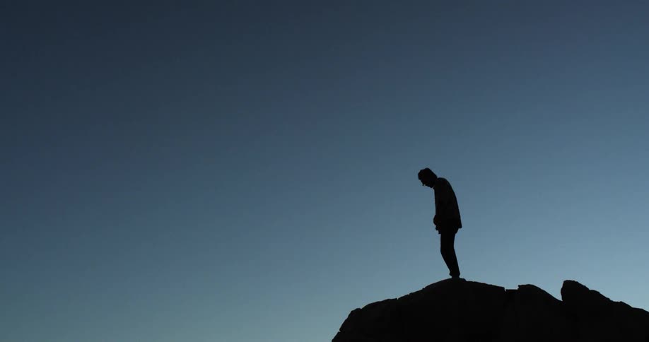 A person walks to the edge of the cliff