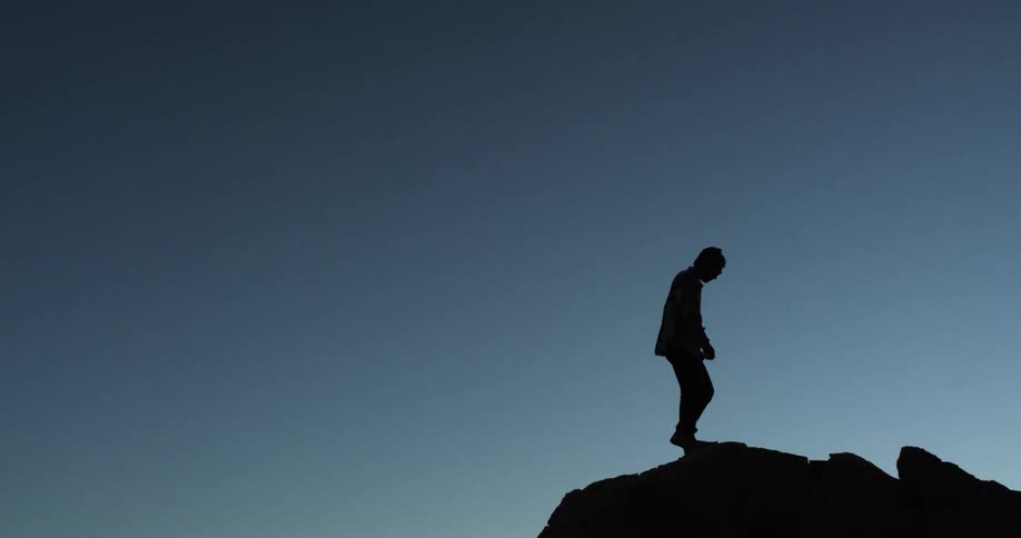 A man walks along the cliff on the mountain