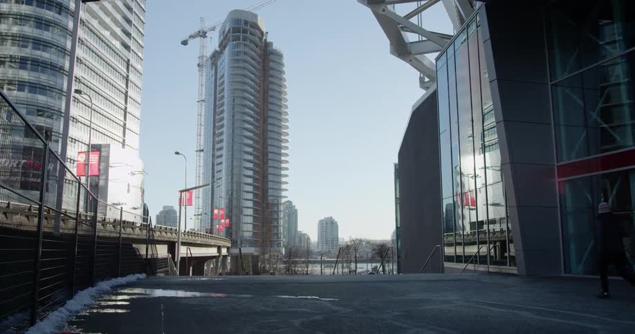 A fenced walkway outside of a building in a city on a sunny winter day