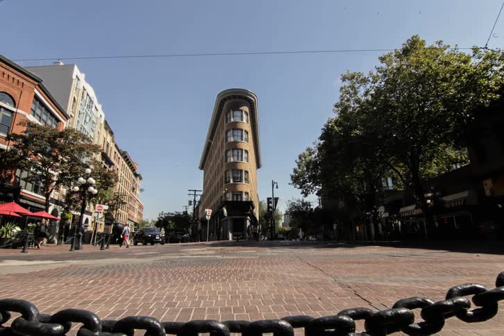 A city street with people vehicles and buildings