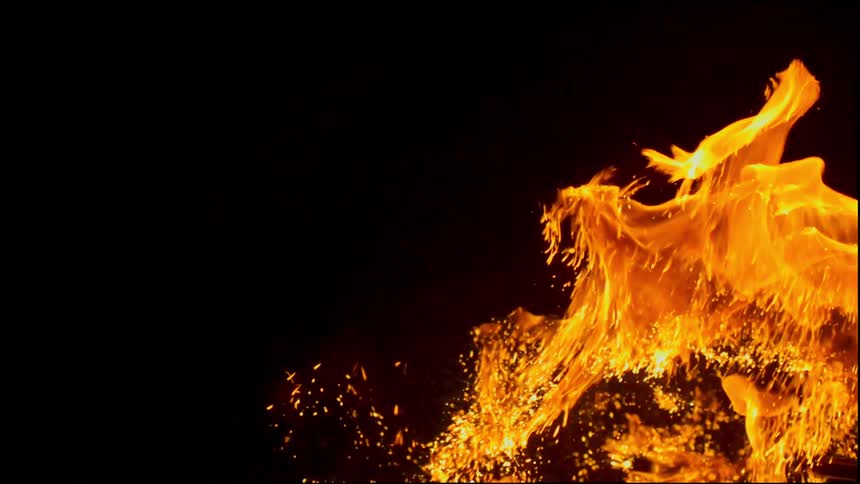 Flames burning in slow motion against a black background