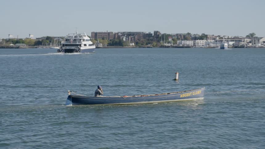 A person sails along a small lake beside a town