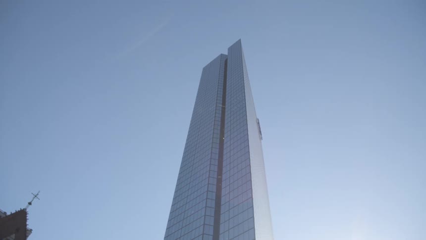 Looking up at a city skyscraper with a church beside it