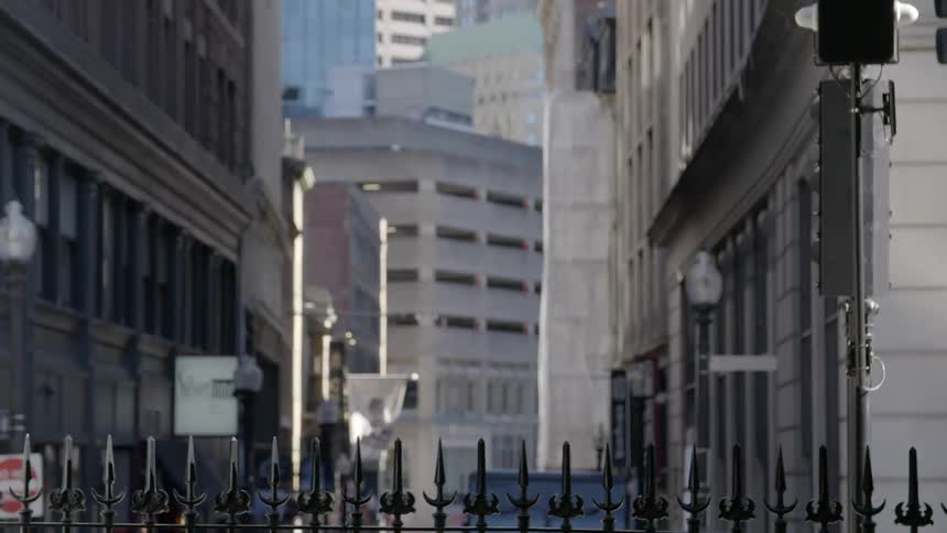 The fence sits in front of the tall buildings