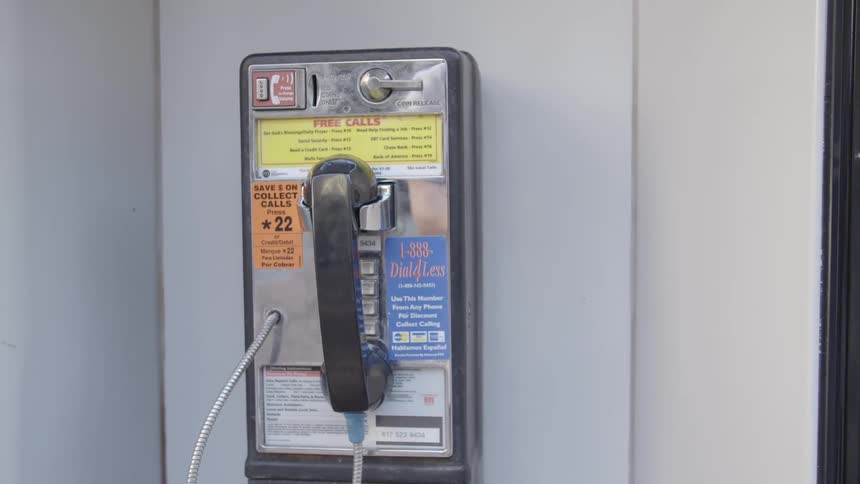 A payphone with stickers on it