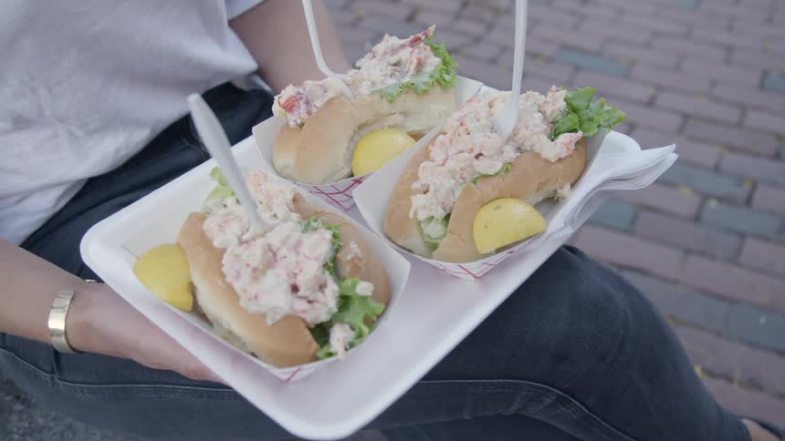 A person sitting down holding a tray of food