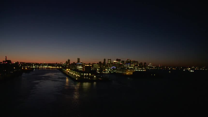 The city across the water is dark at dusk
