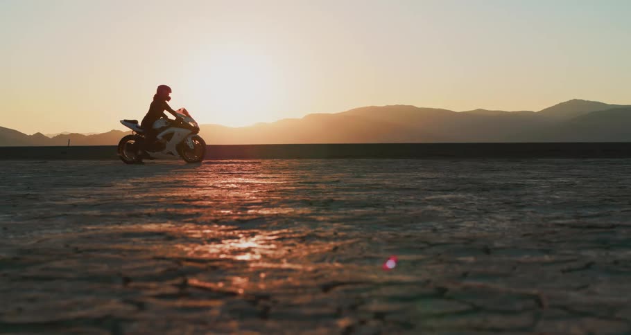 Motorcycle rider travels over the land near the mountains