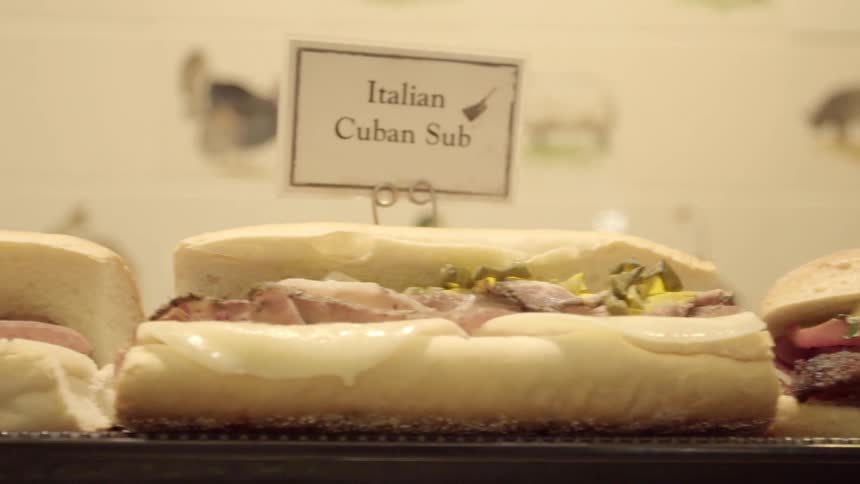 The table is covered with different sub sandwiches