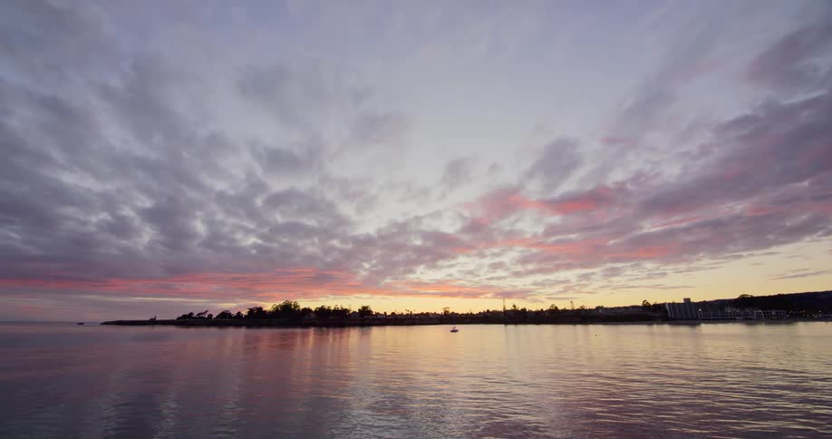 The sun starts to rise over the calm sea